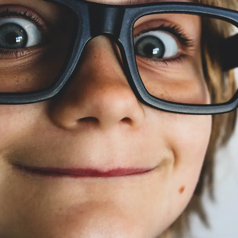 boy with black glasses smiling