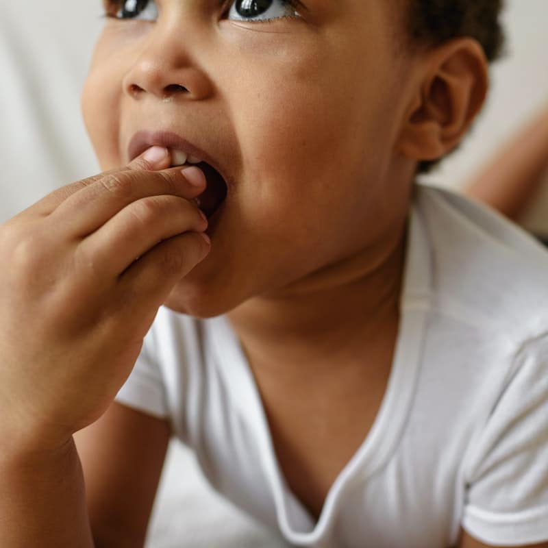 Toddler feeding himself a grape