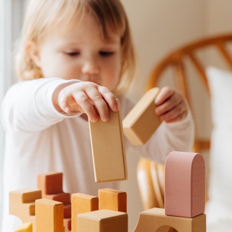 Baby using fine motor skills to place blocks on top of one another